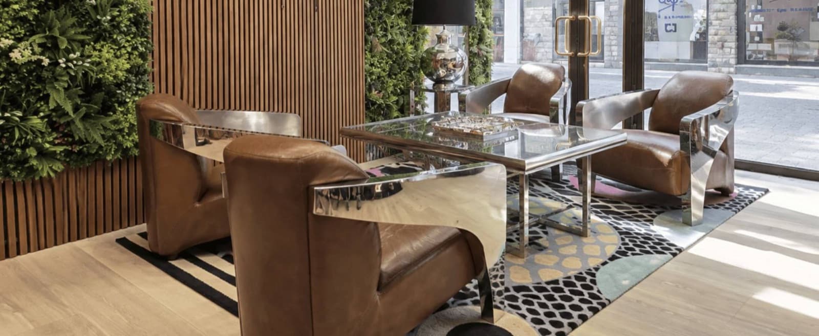 Espace d'accueil avec fauteuils en cuir et mur végétal